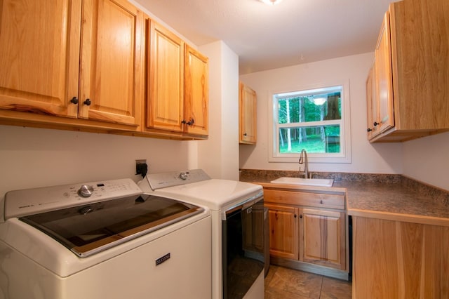 washroom with sink, light tile patterned floors, washer and clothes dryer, and cabinets