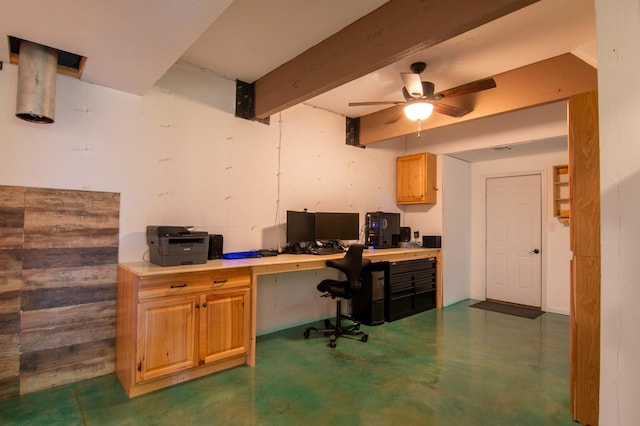 home office featuring beamed ceiling, ceiling fan, and built in desk