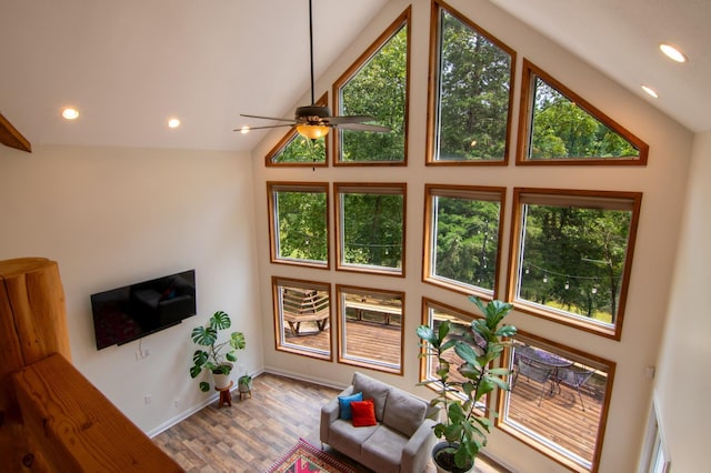 living room featuring hardwood / wood-style flooring, ceiling fan, and high vaulted ceiling