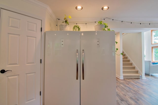 kitchen featuring white refrigerator, ornamental molding, and hardwood / wood-style floors