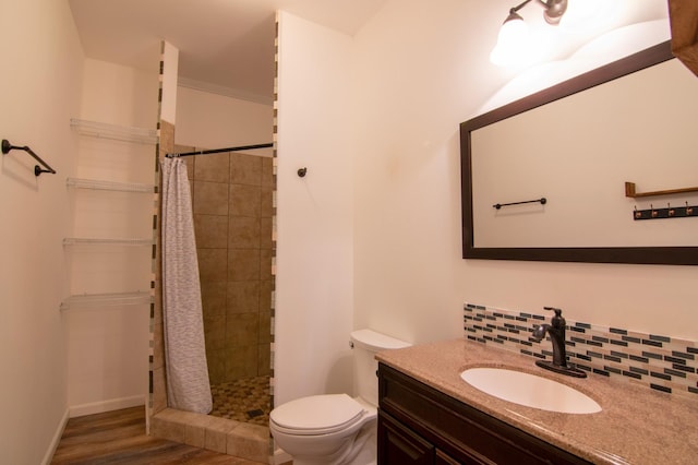 bathroom featuring hardwood / wood-style floors, backsplash, vanity, walk in shower, and toilet