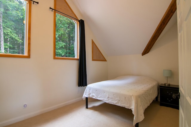 carpeted bedroom featuring lofted ceiling with beams