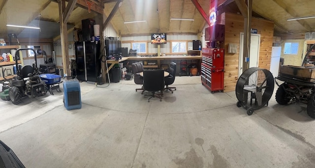 garage with wooden walls and a workshop area