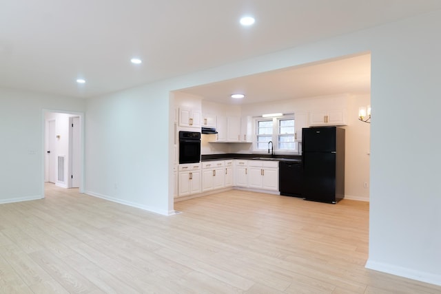 kitchen with sink, light hardwood / wood-style floors, white cabinetry, and black appliances