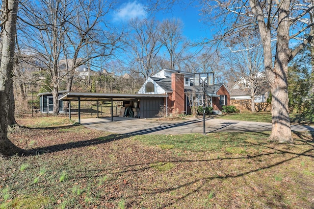 rear view of property with a carport and a lawn