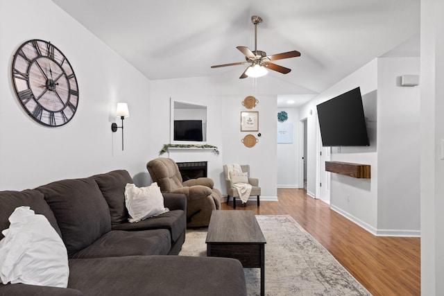 living room featuring hardwood / wood-style flooring, ceiling fan, and lofted ceiling