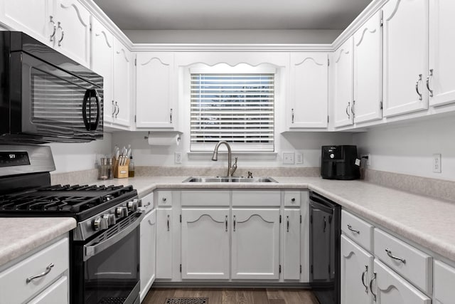 kitchen featuring black appliances, white cabinets, and sink