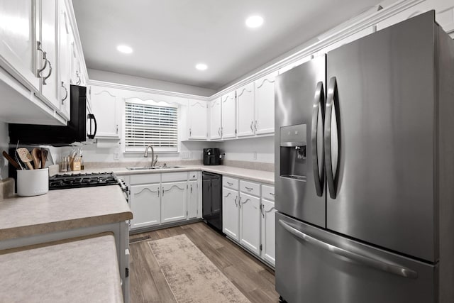 kitchen with white cabinets, sink, dark hardwood / wood-style floors, stainless steel fridge, and black dishwasher