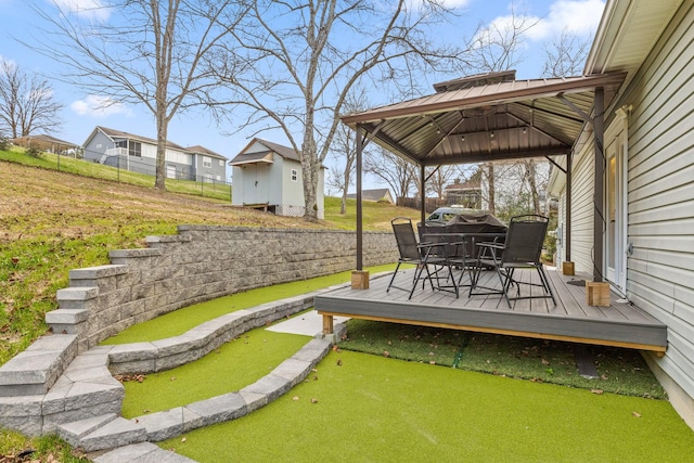 exterior space featuring a gazebo, a deck, and a storage unit