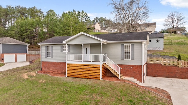 view of front of home with an outdoor structure, a front lawn, a porch, and a garage