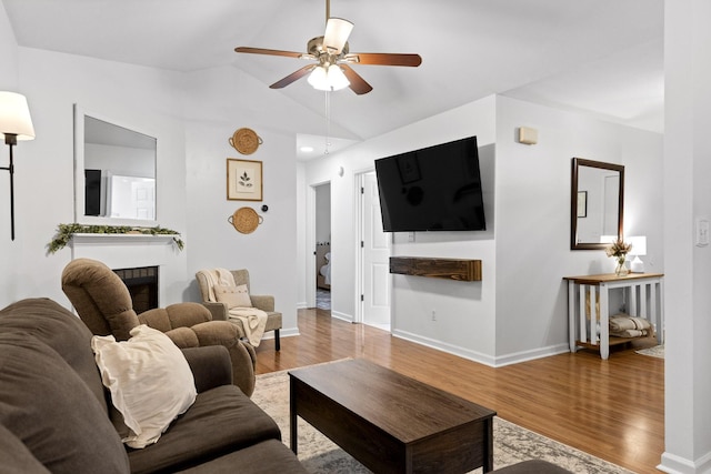 living room with ceiling fan, wood-type flooring, and lofted ceiling