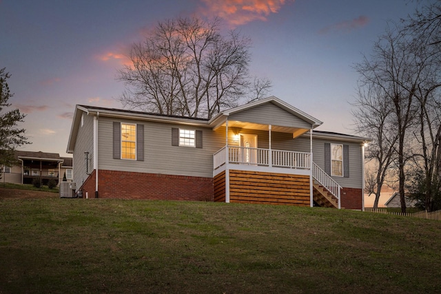 view of front of property with a lawn, central AC unit, and a porch