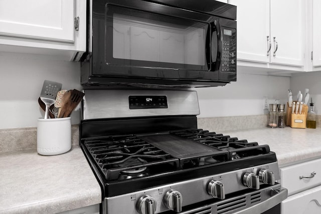 interior details with gas range and white cabinets