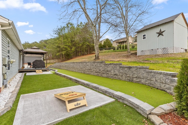 view of yard featuring a gazebo, a fire pit, an outbuilding, and a wooden deck