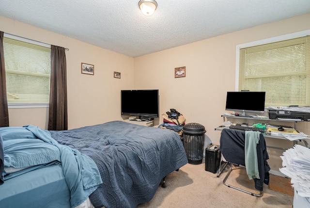 bedroom with light colored carpet and a textured ceiling