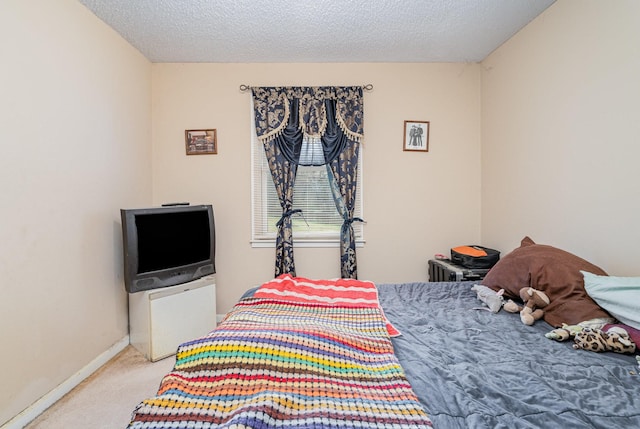 bedroom featuring a textured ceiling and light colored carpet