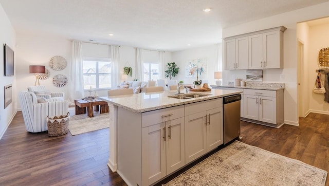 kitchen featuring stainless steel dishwasher, sink, dark hardwood / wood-style flooring, and light stone counters