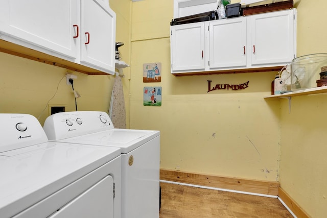 laundry room featuring washer and clothes dryer and cabinets