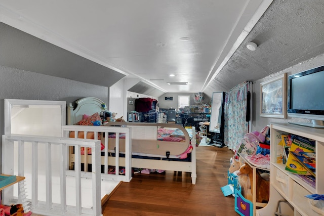 bedroom featuring hardwood / wood-style floors and lofted ceiling