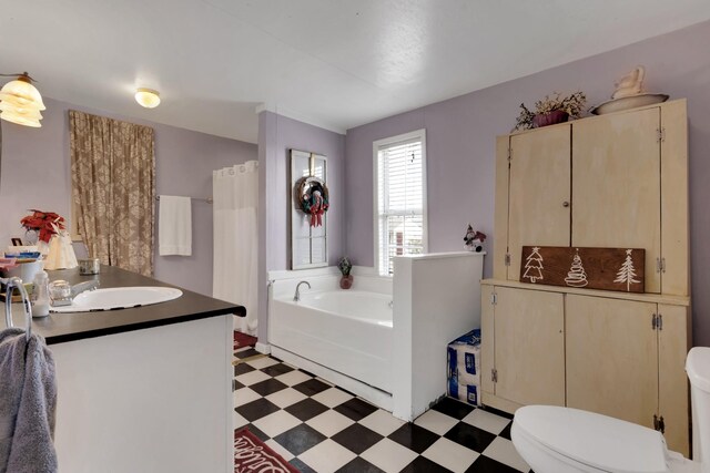 bathroom with vanity, a bath, and toilet