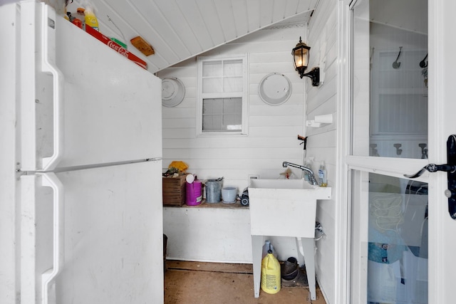 bathroom featuring wood walls and vaulted ceiling