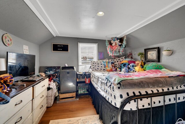 bedroom featuring light hardwood / wood-style floors and vaulted ceiling