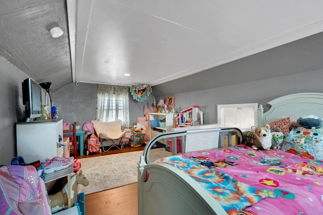 bedroom featuring wood-type flooring, a textured ceiling, and vaulted ceiling