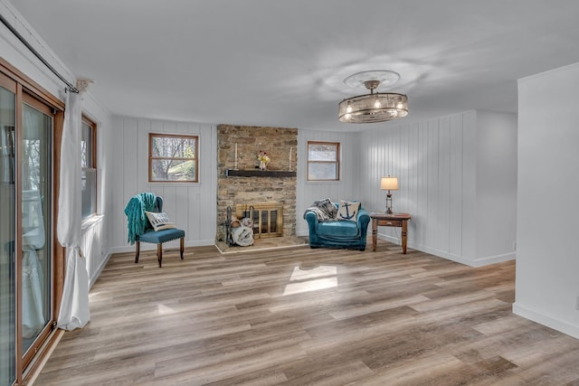 unfurnished room featuring baseboards, wood finished floors, and a fireplace