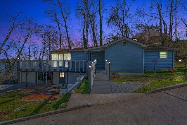 view of front of home with a garage, a wooden deck, and driveway