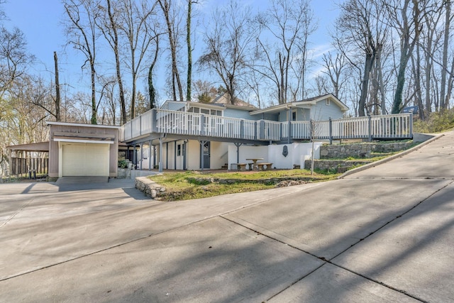 view of front of property featuring a deck, concrete driveway, and an attached garage