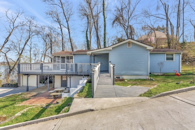 view of front of property with a garage, a deck, driveway, and a sunroom