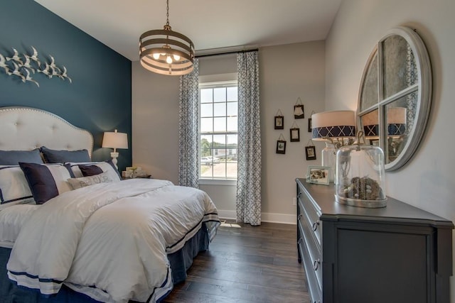 bedroom with dark hardwood / wood-style flooring and a chandelier