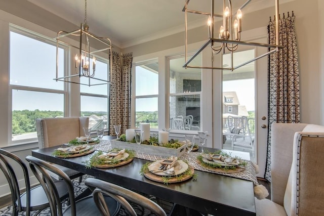 dining space with hardwood / wood-style flooring, a notable chandelier, plenty of natural light, and crown molding