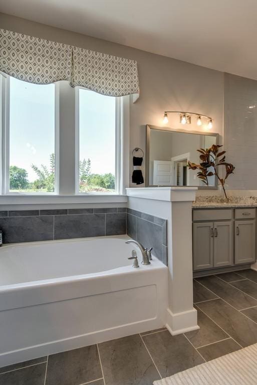 bathroom with tile patterned floors, vanity, and a bathing tub