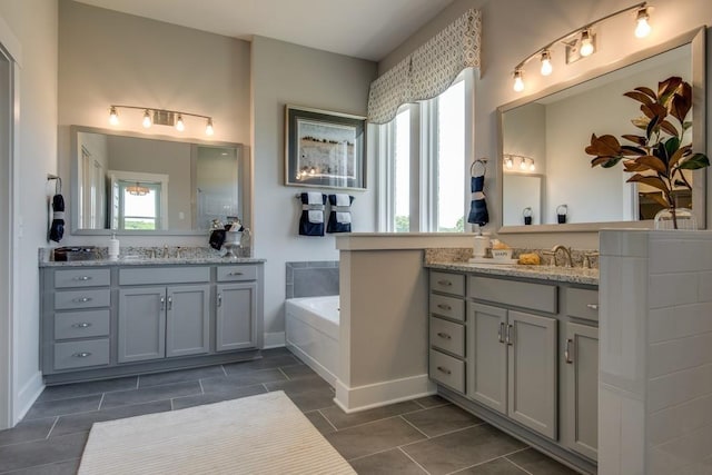 bathroom with a bathing tub, tile patterned flooring, and vanity