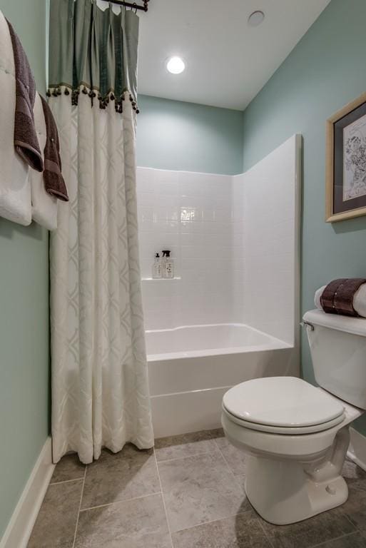 bathroom featuring tile patterned flooring, shower / tub combo, and toilet