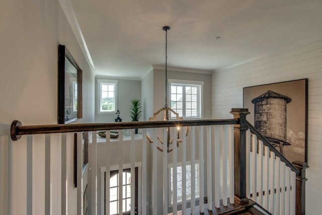 staircase featuring crown molding and a chandelier