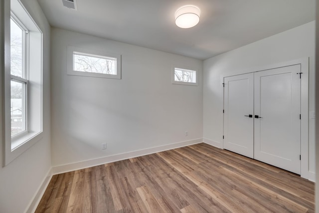 unfurnished bedroom featuring a closet and light hardwood / wood-style flooring