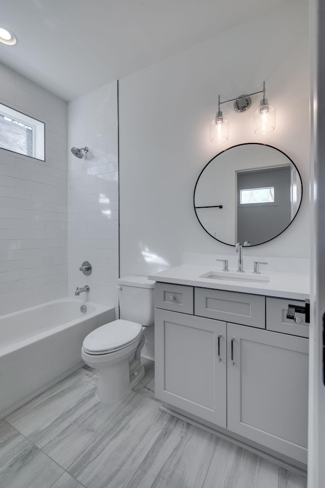 full bathroom featuring vanity, toilet, and tiled shower / bath