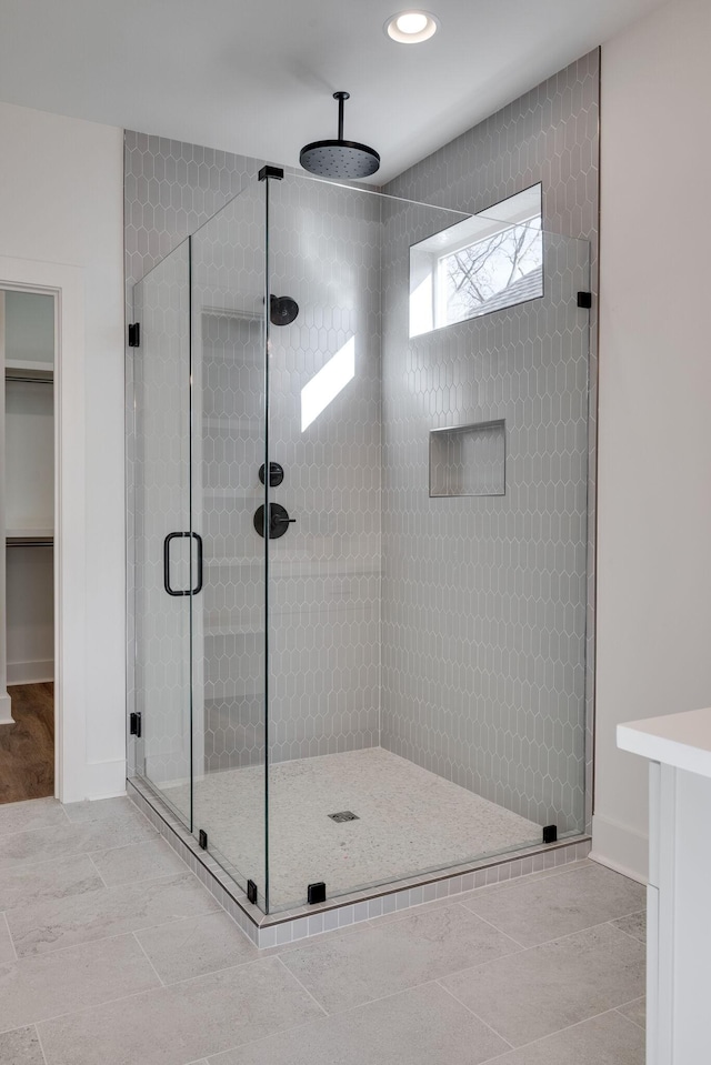 bathroom with an enclosed shower and tile patterned flooring