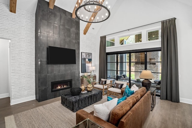 living room with beamed ceiling, wood-type flooring, a fireplace, and high vaulted ceiling