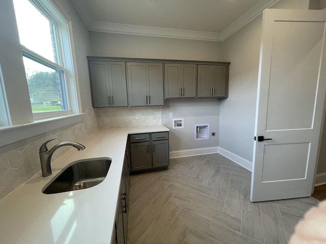 laundry room with cabinets, sink, hookup for a washing machine, hookup for an electric dryer, and light parquet flooring