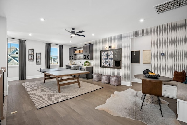 recreation room with ceiling fan and dark wood-type flooring