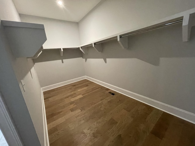 spacious closet with dark hardwood / wood-style flooring