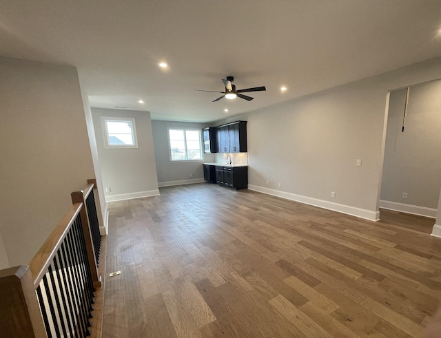 unfurnished living room featuring ceiling fan, hardwood / wood-style floors, and sink