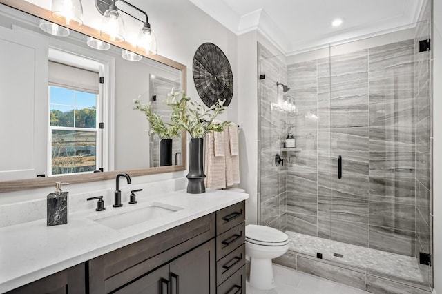 bathroom featuring vanity, toilet, a shower with shower door, and crown molding