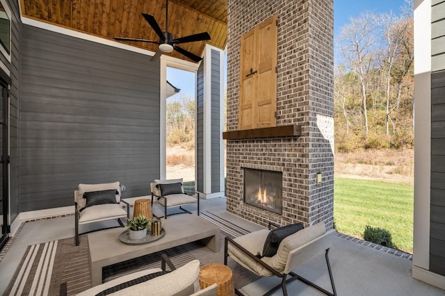 view of patio with an outdoor living space with a fireplace and ceiling fan