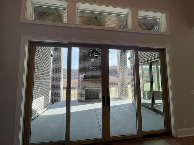 doorway to outside with a fireplace, french doors, and hardwood / wood-style flooring