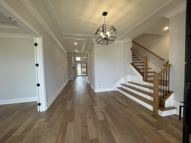 foyer with crown molding, dark hardwood / wood-style flooring, and an inviting chandelier