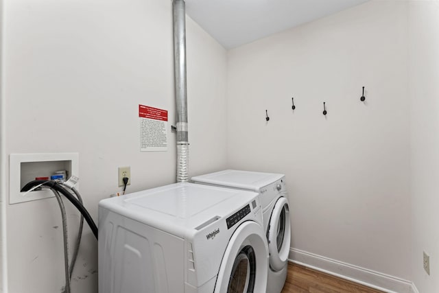 washroom with washing machine and clothes dryer and dark hardwood / wood-style flooring